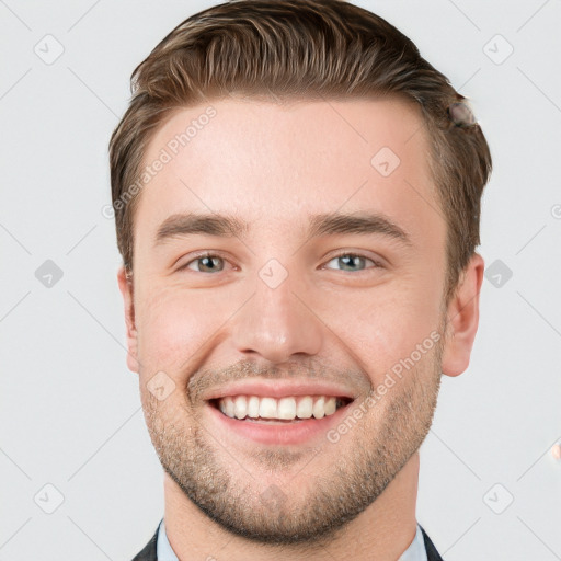 Joyful white young-adult male with short  brown hair and grey eyes