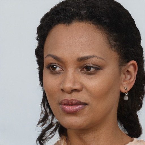 Joyful black young-adult female with medium  black hair and brown eyes