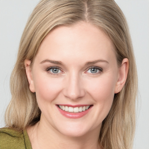 Joyful white young-adult female with long  brown hair and blue eyes