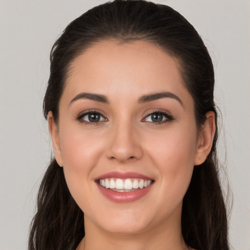 Joyful white young-adult female with long  brown hair and brown eyes