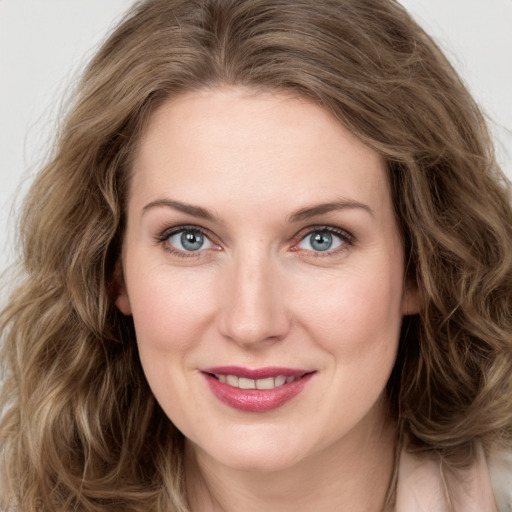 Joyful white young-adult female with long  brown hair and green eyes