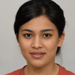 Joyful latino young-adult female with medium  brown hair and brown eyes