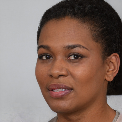 Joyful black young-adult female with short  black hair and brown eyes
