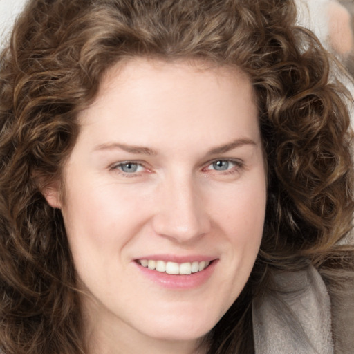 Joyful white young-adult female with long  brown hair and green eyes