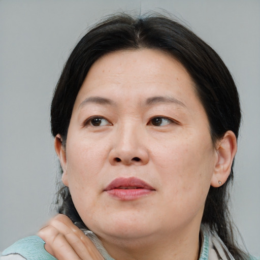 Joyful asian adult female with medium  brown hair and brown eyes