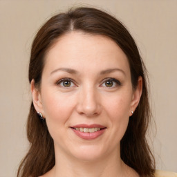 Joyful white adult female with long  brown hair and grey eyes