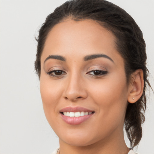 Joyful latino young-adult female with long  brown hair and brown eyes