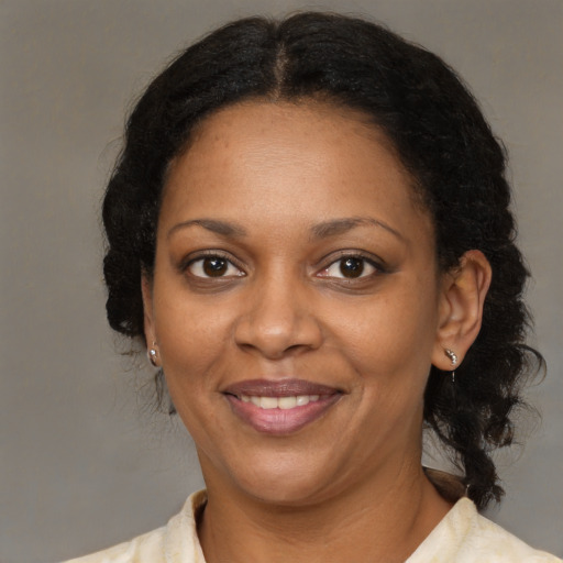 Joyful black adult female with medium  brown hair and brown eyes