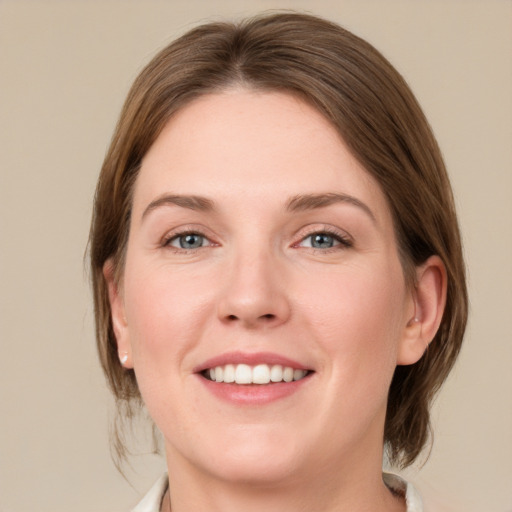 Joyful white young-adult female with medium  brown hair and grey eyes