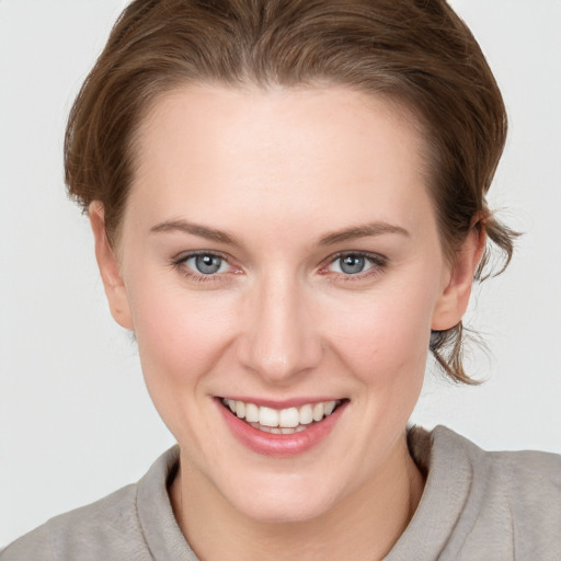 Joyful white young-adult female with short  brown hair and grey eyes