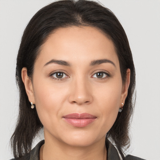 Joyful latino young-adult female with medium  brown hair and brown eyes