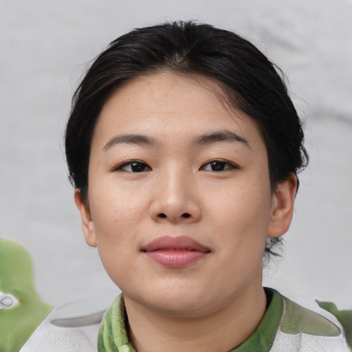 Joyful asian young-adult female with short  brown hair and brown eyes