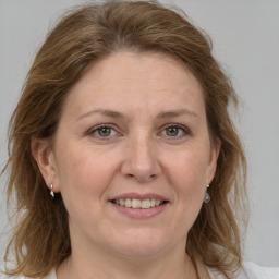 Joyful white adult female with medium  brown hair and grey eyes