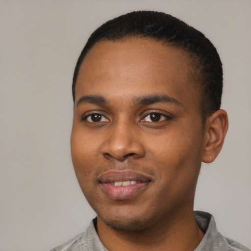 Joyful black young-adult male with short  black hair and brown eyes