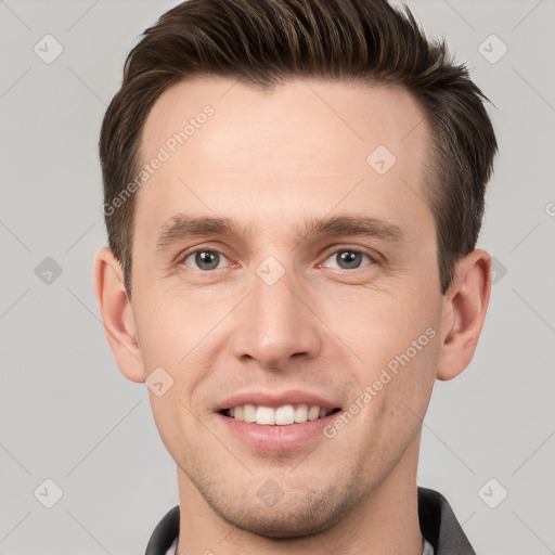 Joyful white young-adult male with short  brown hair and grey eyes