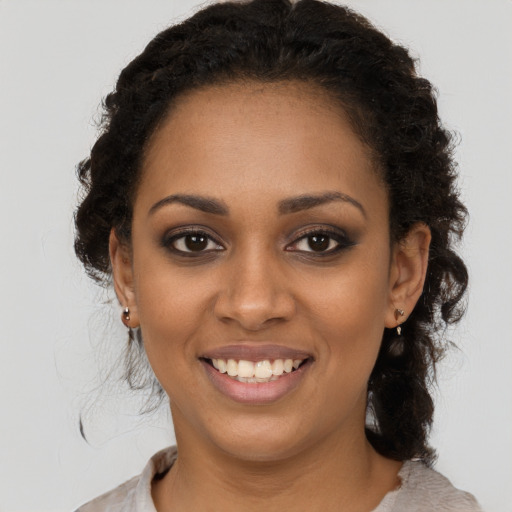 Joyful black young-adult female with medium  brown hair and brown eyes