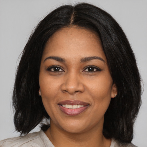 Joyful black young-adult female with medium  black hair and brown eyes