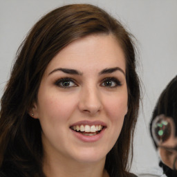 Joyful white young-adult female with long  brown hair and green eyes