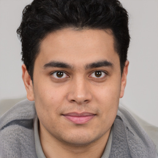 Joyful latino young-adult male with short  brown hair and brown eyes