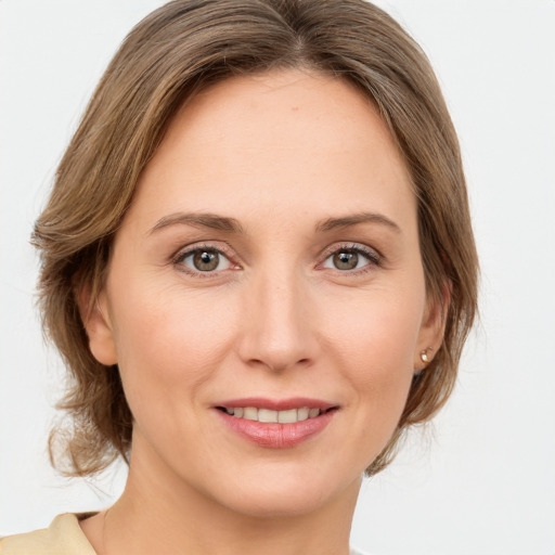 Joyful white young-adult female with medium  brown hair and green eyes