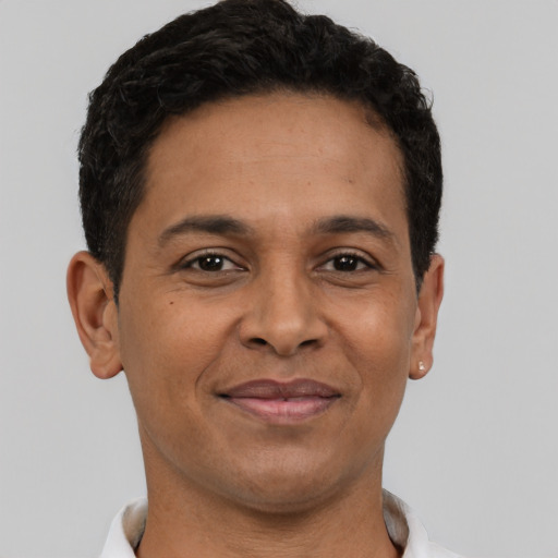 Joyful black adult male with short  brown hair and brown eyes