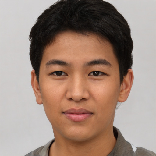 Joyful asian young-adult male with short  black hair and brown eyes