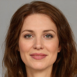 Joyful white young-adult female with long  brown hair and green eyes