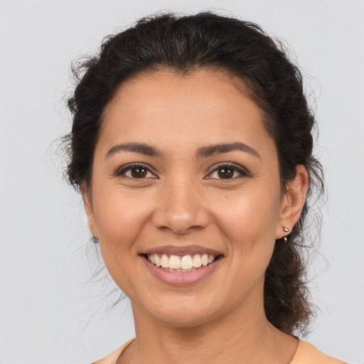 Joyful latino young-adult female with medium  brown hair and brown eyes
