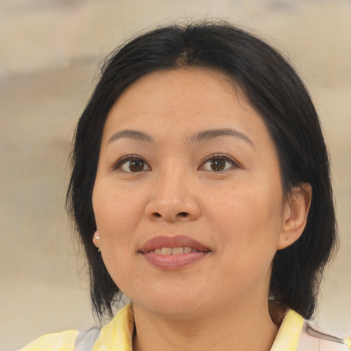 Joyful asian young-adult female with medium  brown hair and brown eyes