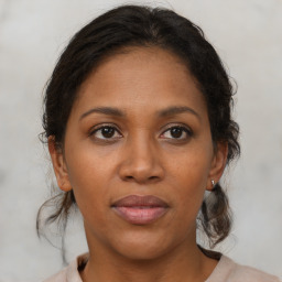 Joyful black adult female with medium  brown hair and brown eyes