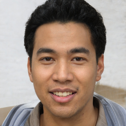 Joyful asian young-adult male with short  black hair and brown eyes