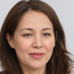 Joyful white adult female with long  brown hair and brown eyes