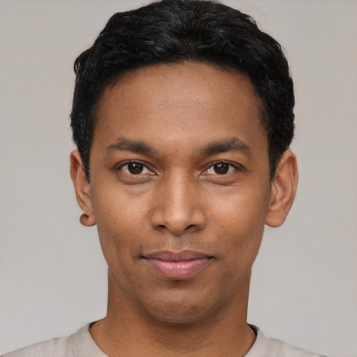 Joyful latino young-adult male with short  black hair and brown eyes