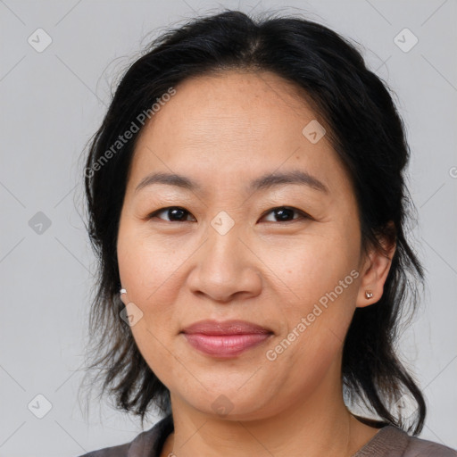 Joyful asian adult female with medium  brown hair and brown eyes