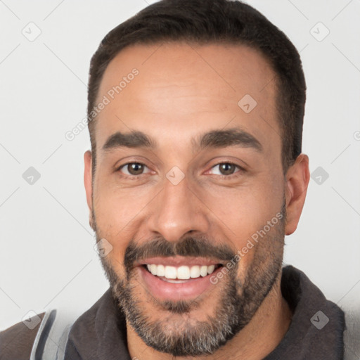 Joyful white young-adult male with short  black hair and brown eyes