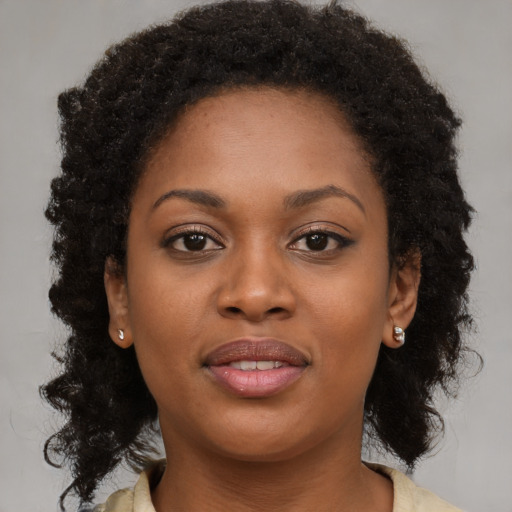 Joyful black young-adult female with medium  brown hair and brown eyes