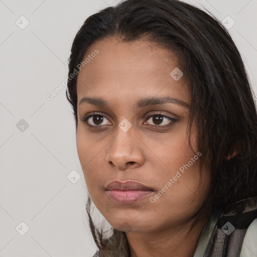 Joyful black young-adult female with long  brown hair and brown eyes