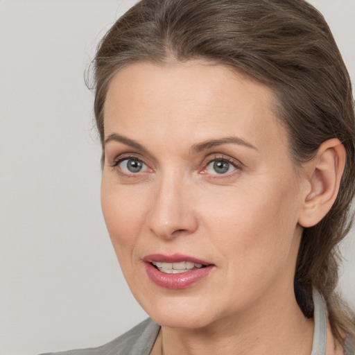 Joyful white adult female with medium  brown hair and brown eyes