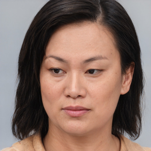 Joyful asian adult female with medium  brown hair and brown eyes