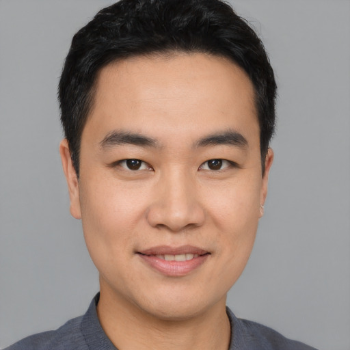 Joyful asian young-adult male with short  black hair and brown eyes