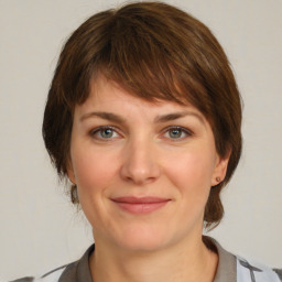 Joyful white young-adult female with medium  brown hair and grey eyes