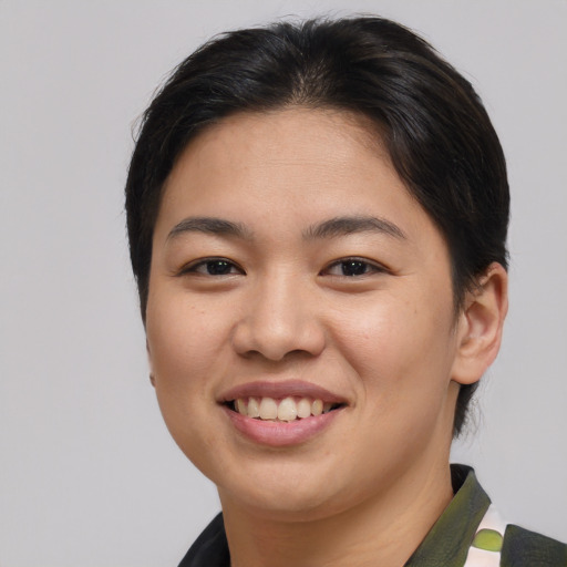 Joyful asian young-adult female with short  brown hair and brown eyes