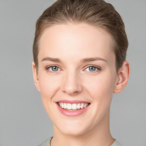 Joyful white young-adult female with short  brown hair and grey eyes