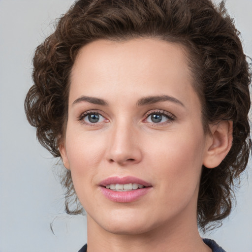 Joyful white young-adult female with medium  brown hair and green eyes