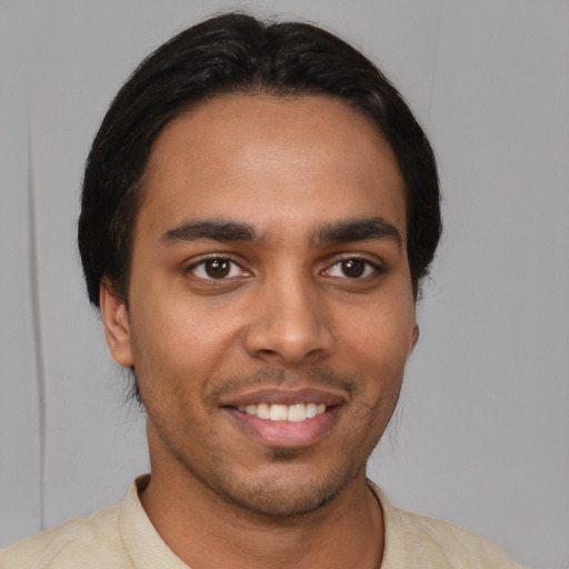 Joyful latino young-adult male with short  brown hair and brown eyes