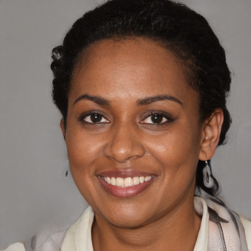 Joyful black young-adult female with short  brown hair and brown eyes