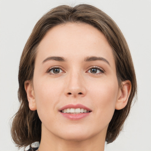 Joyful white young-adult female with medium  brown hair and green eyes