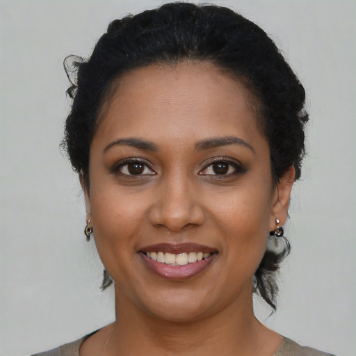 Joyful black young-adult female with medium  black hair and brown eyes