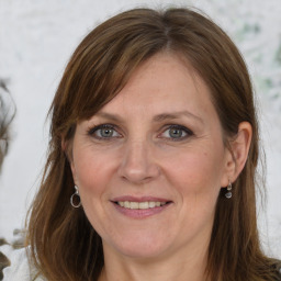 Joyful white adult female with medium  brown hair and grey eyes