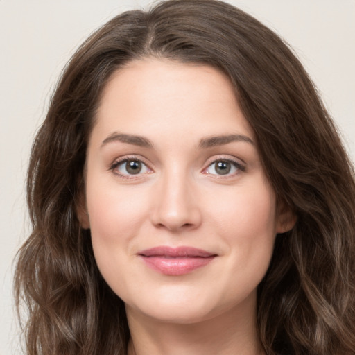 Joyful white young-adult female with long  brown hair and green eyes